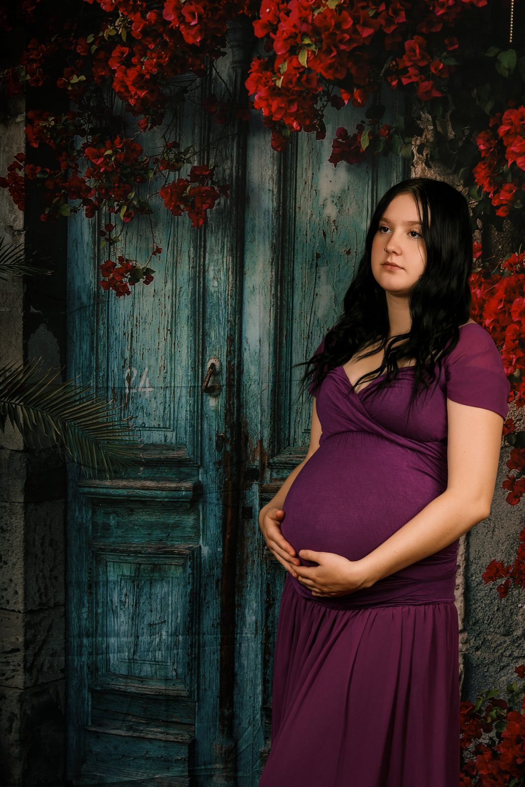 Maternity portrait in a deep plum gown against a rustic door, Mattoon IL studio